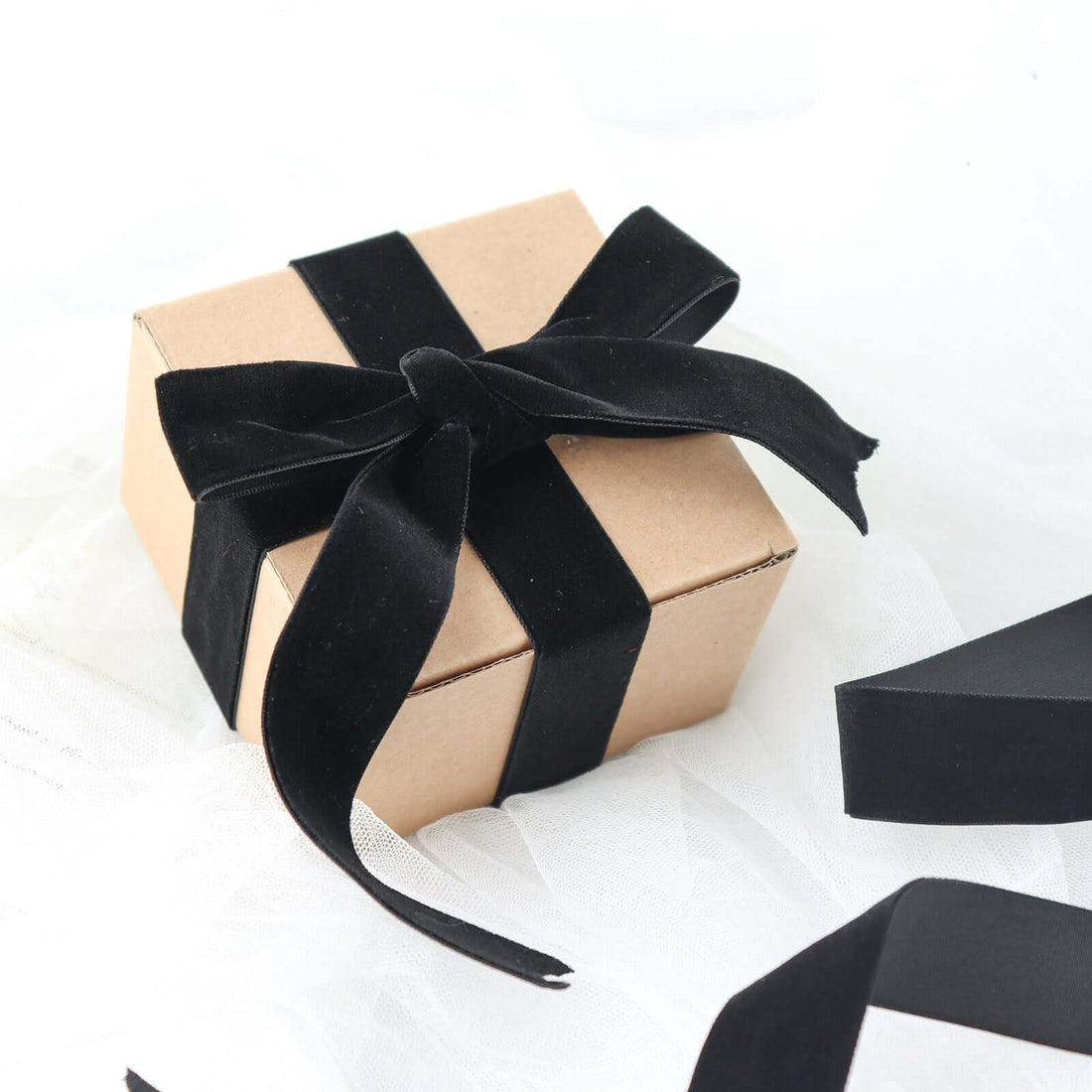 Gift box with black ribbon on soft white fabric