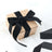Gift box with black ribbon on soft white fabric