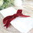 Elegant white napkin tied with a burgundy velvet ribbon on a decorative plate.