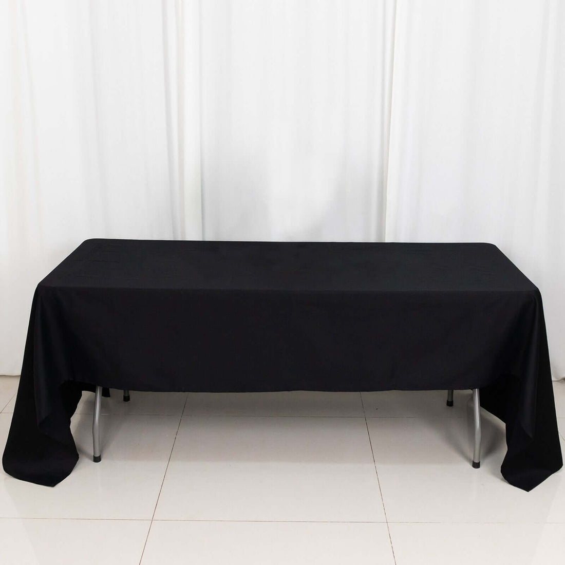 Black tablecloth draped over a rectangular table in a studio setting.