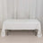 White table covered with a plain tablecloth in a studio setting.