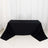 Black tablecloth draped over a table in a studio setting.