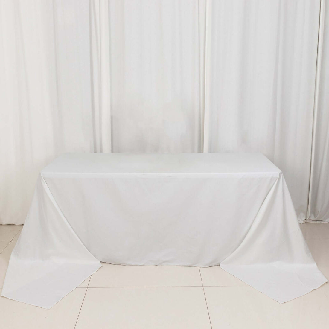 White tablecloth draped over a table in a studio setting.