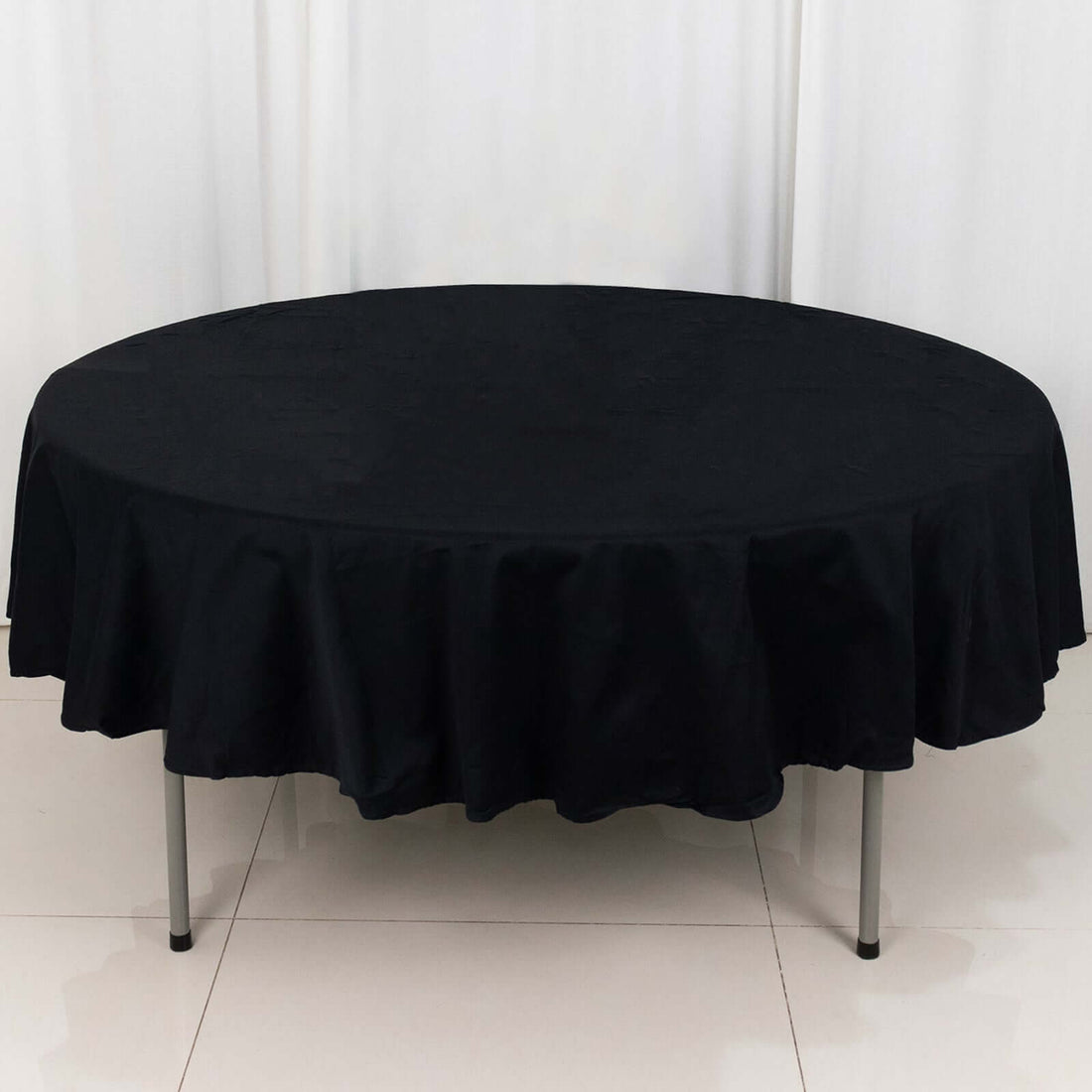 Black round tablecloth draped over a circular table
