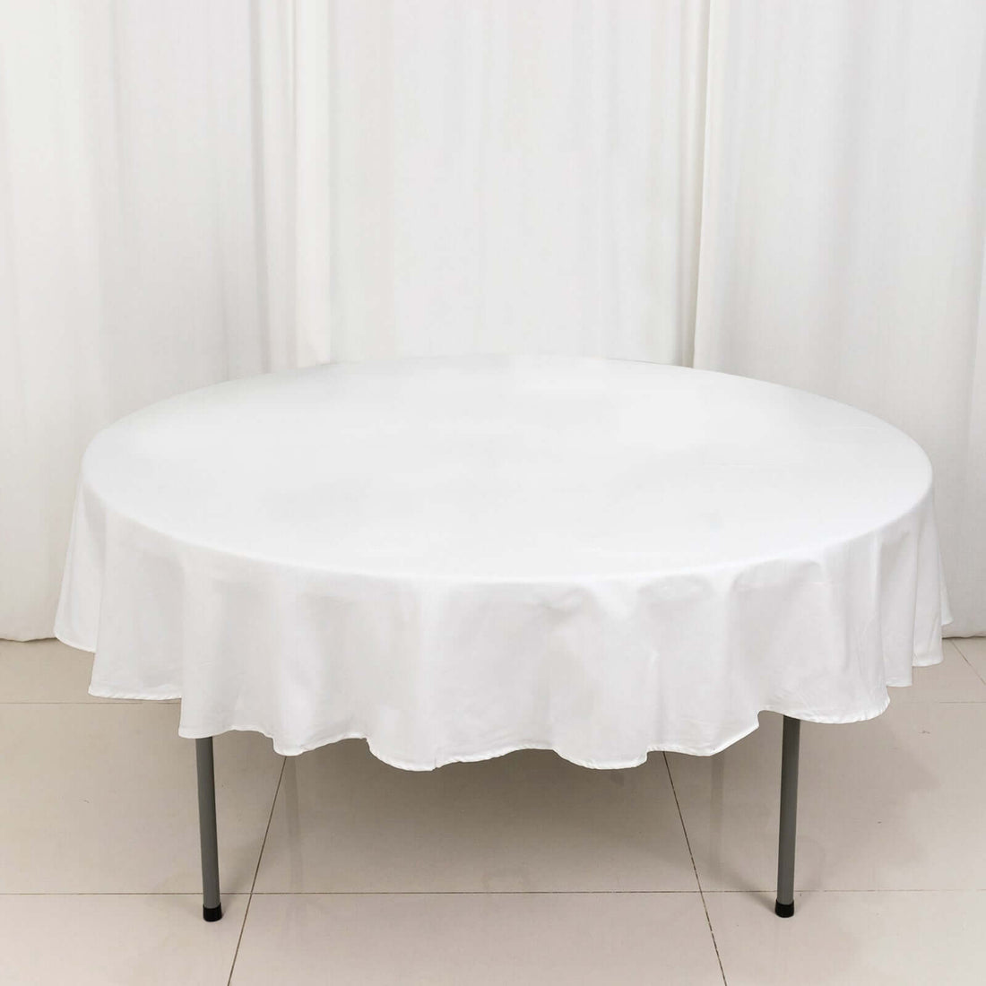 Round white tablecloth draped over a circular table