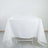 White tablecloth draping over a table in a studio setting.