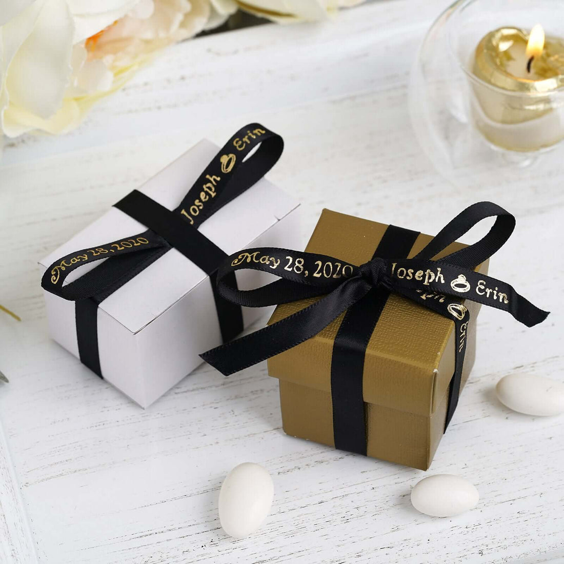 Elegant white and gold gift boxes with black ribbons for weddings or special events.