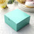 Turquoise gift box with a sliding lid on a lace tablecloth.