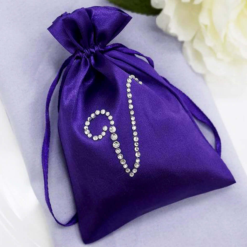Purple satin drawstring pouch with rhinestone design.