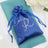 Blue satin pouch with rhinestone monogram on a teal napkin.