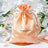 Peach satin drawstring bag with logo, perfect for gifts or party favors.