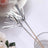 Silver decorative metallic straws with a wooden base.