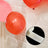 Red and pink balloons with adhesive dots for easy hanging.
