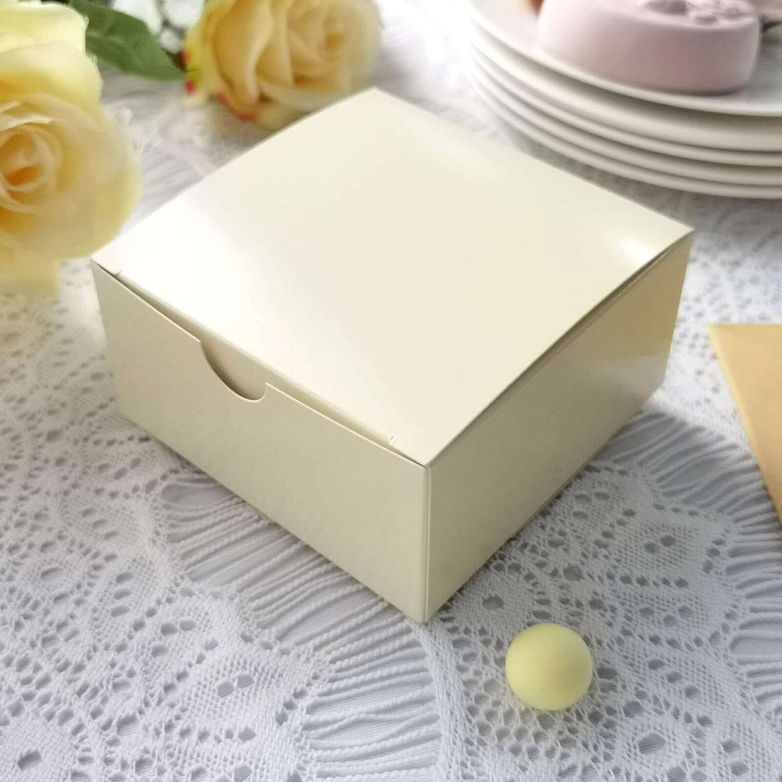 Cream-colored gift box with a smooth finish on lace tablecloth.