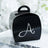 Black gift box with decorative silver letter "A" on a white plate.