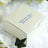 Personalized wedding favor box with names and date printed in blue.