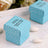 Blue polka dot gift boxes on a wooden surface with white almonds.