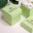 Green gift boxes with personalized labels for weddings.