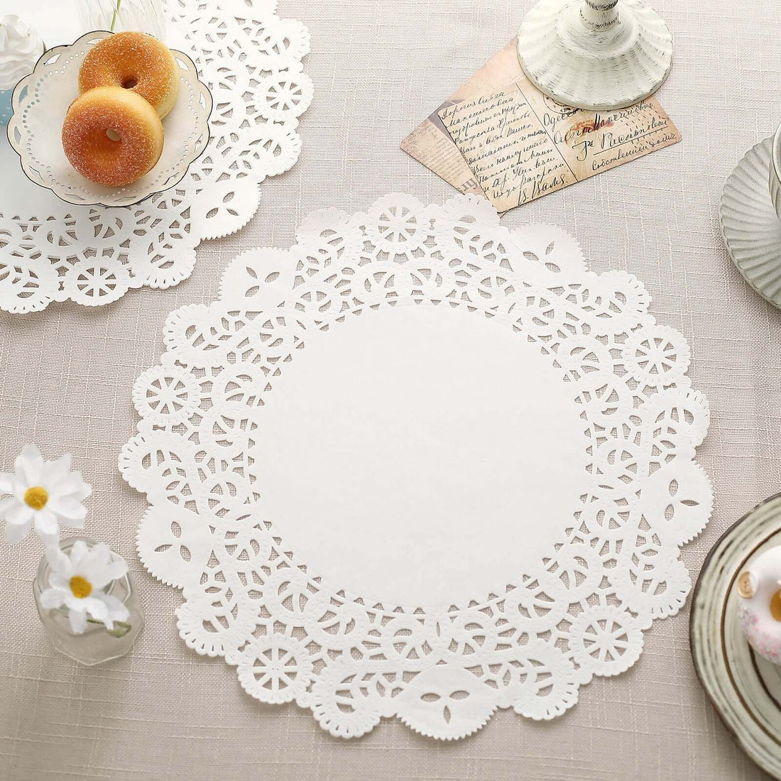 White lace doily on a textured tablecloth with decorative elements