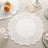 White lace doily on a textured tablecloth with decorative elements