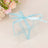 Clear gift box tied with a blue ribbon, surrounded by flowers.