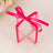 Clear gift box with pink ribbon bow on a neutral background.