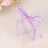Clear gift box with a lavender ribbon on a soft background.