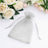 Silver organza gift bag on a soft white surface with flowers.