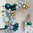 Colorful balloon arch decoration in shades of teal, silver, and gold.