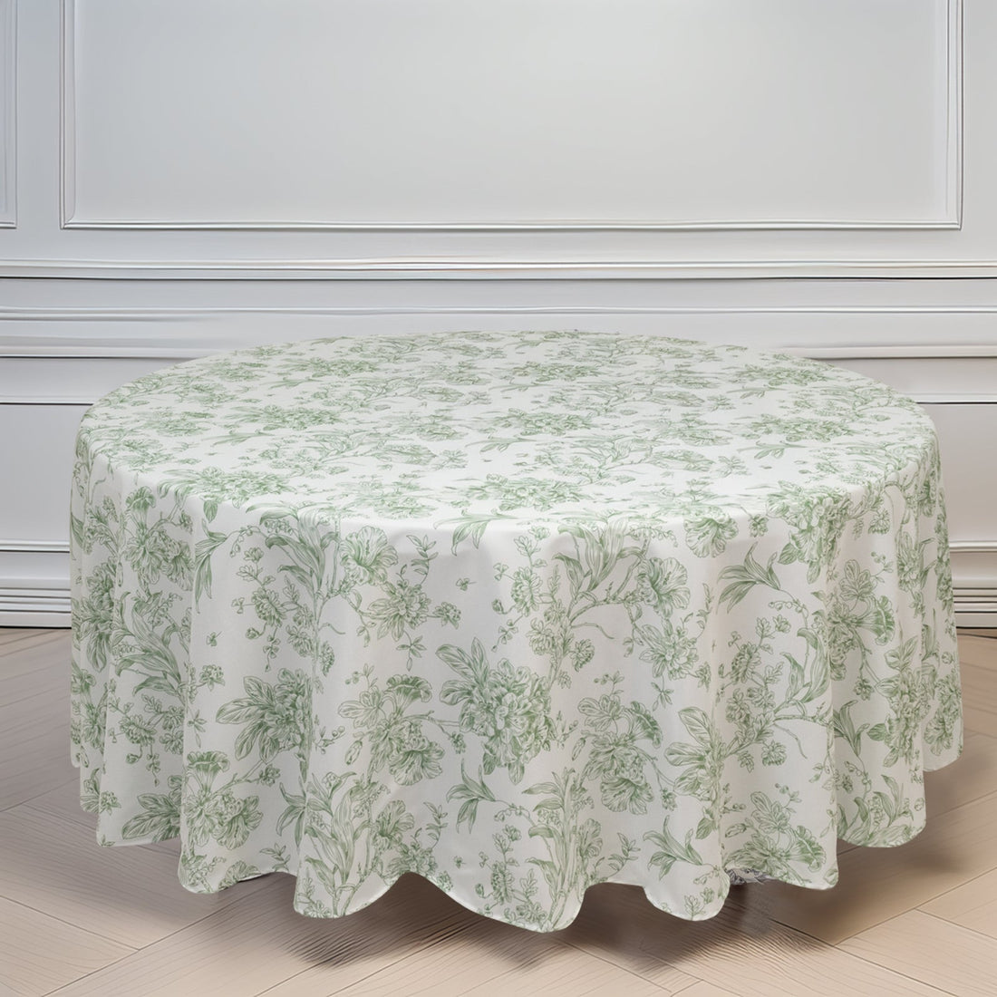 Round floral tablecloth in green and white on a plain backdrop.