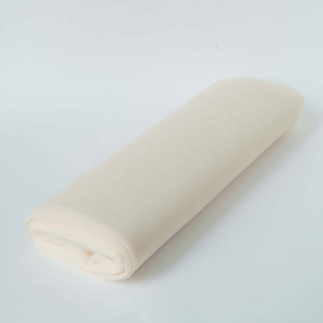 Rolled cream-colored fabric on a plain background