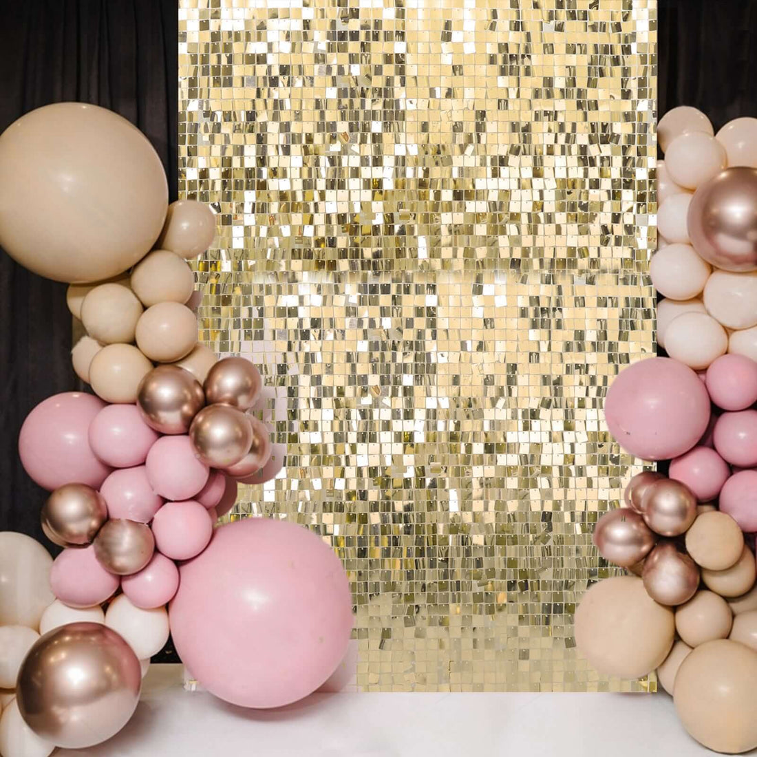 Balloon arch decoration with a shimmering gold backdrop for events.