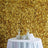 Elegant table setting with champagne flutes and floral decor against a golden wall.