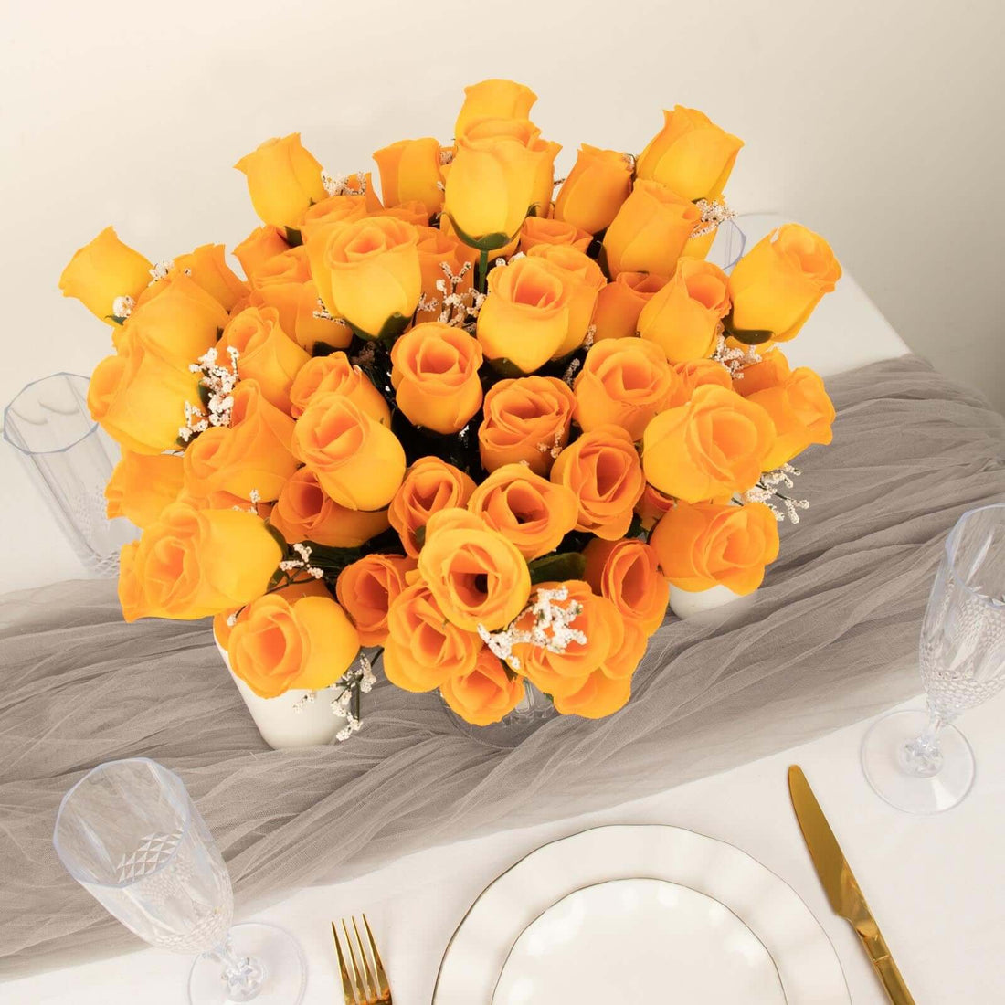 Bright yellow roses bouquet on a table with elegant dinnerware.