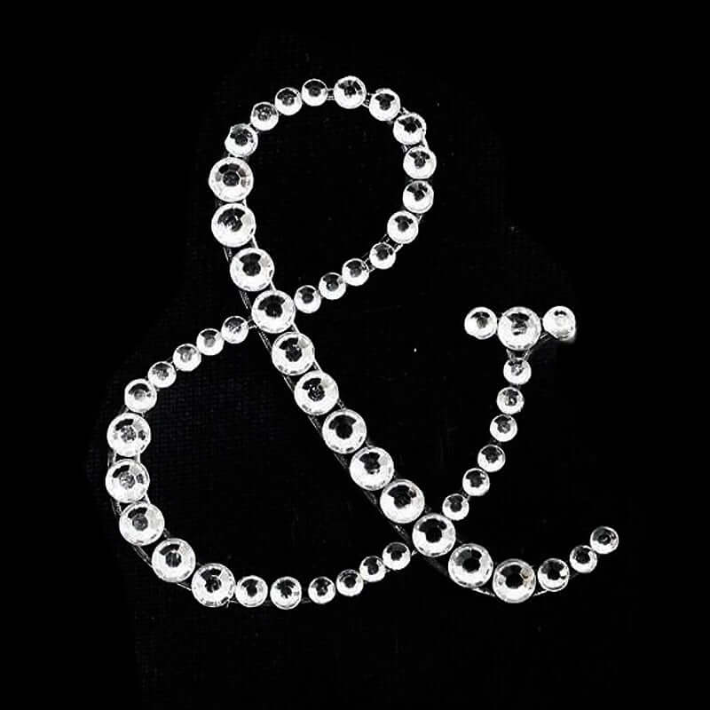 Rhinestone ampersand decoration on black background.