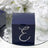 Navy blue gift box adorned with rhinestones on a reflective surface.