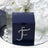 Navy gift box adorned with rhinestones on a reflective surface
