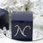 Navy blue gift box with rhinestone 'N' design on a reflective surface