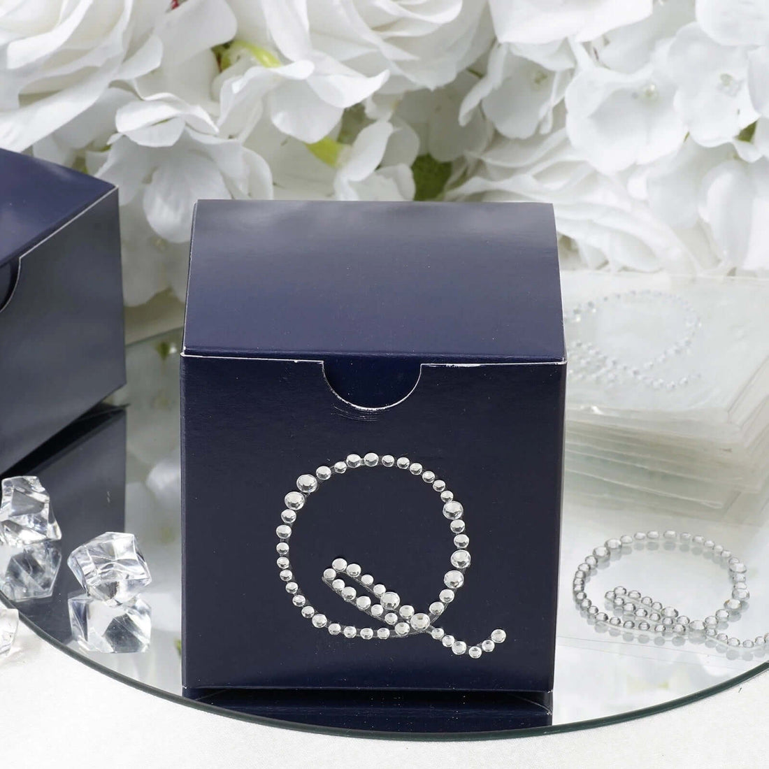Navy gift box with silver bead embellishment on reflective surface