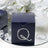 Navy gift box with silver bead embellishment on reflective surface