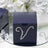 Navy box with rhinestone embellishment on a reflective surface.