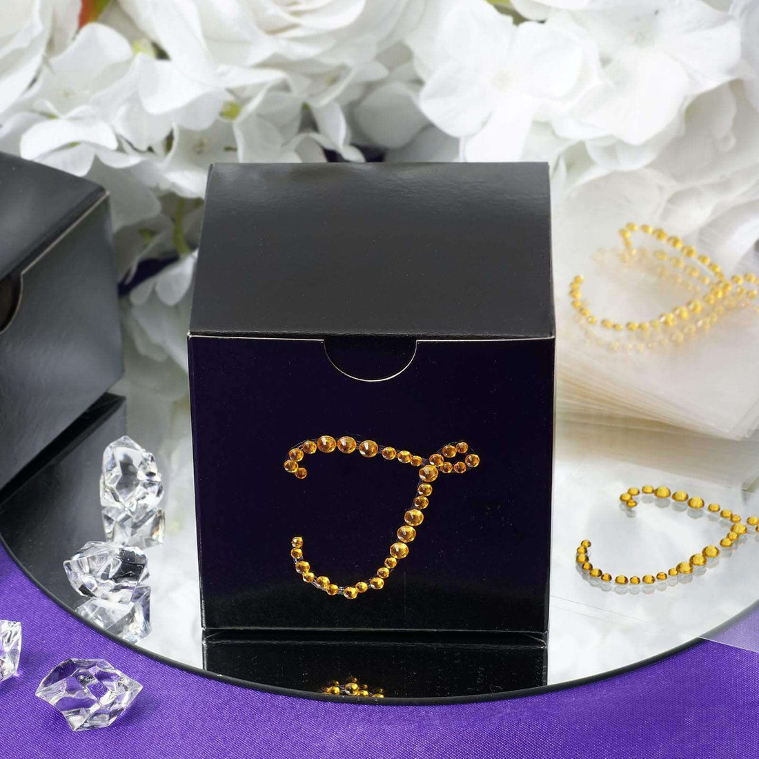 Black gift box adorned with rhinestones in a stylish arrangement.