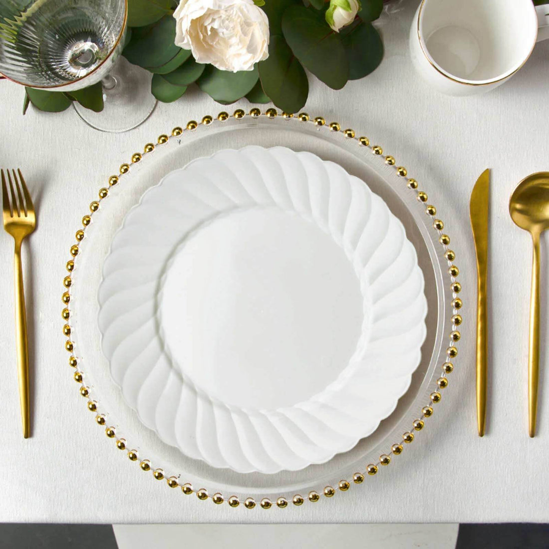 Elegant white plate with gold beaded trim on a stylish tablescape.