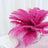 Pink feather arrangement in a glass vase on a table.