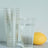 Clear glitter cups with a glass of water and a lemon.