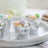 Silver mini buckets filled with pastel-colored eggs on a decorative tray.
