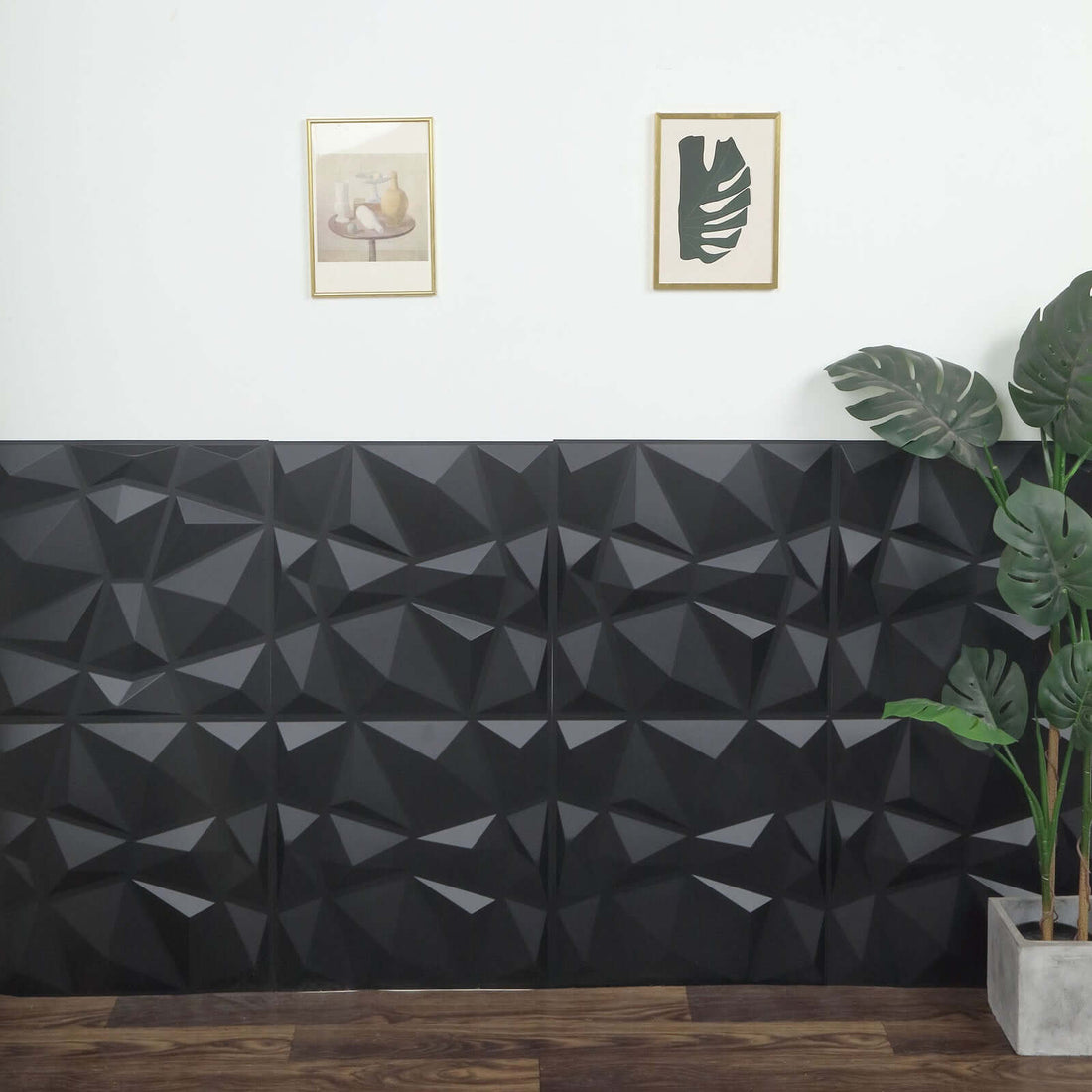 Textured black wall panels with framed art and a plant in a modern interior setting.