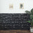 Textured black wall panels with framed art and a plant in a modern interior setting.