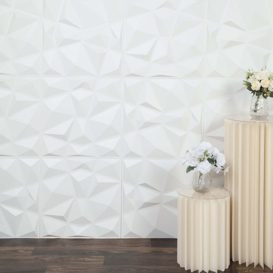 Decorative white 3D wall panels with vases on pedestal tables.