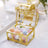 Gold decorative box filled with pastel-colored balls.